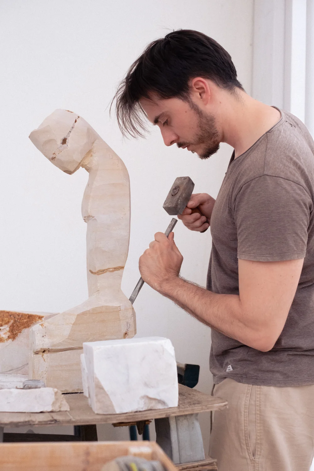 David Gómez tallando una escultura en el taller